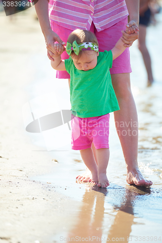 Image of mom and baby on beach  have fun