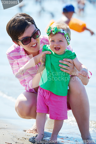 Image of mom and baby on beach  have fun