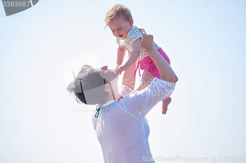 Image of mom and baby on beach  have fun