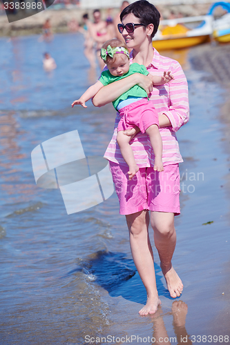 Image of mom and baby on beach  have fun