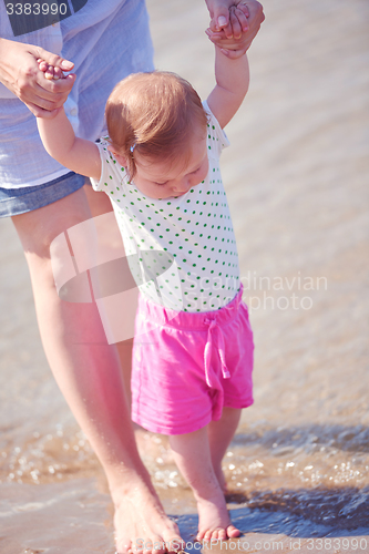 Image of mom and baby on beach  have fun