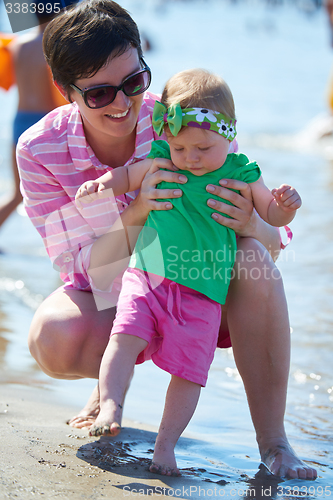 Image of mom and baby on beach  have fun