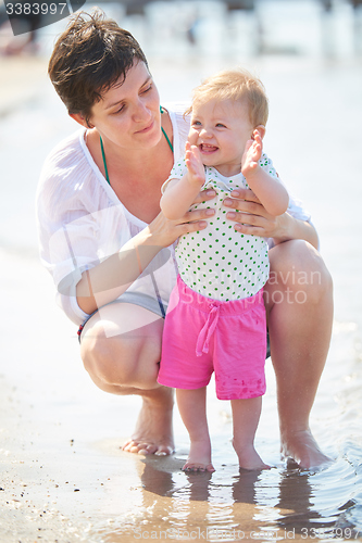 Image of mom and baby on beach  have fun