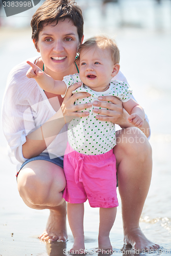 Image of mom and baby on beach  have fun