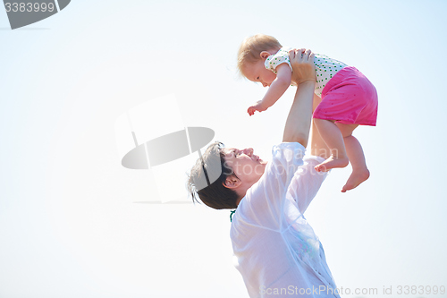 Image of mom and baby on beach  have fun