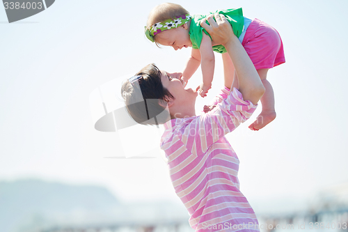 Image of mom and baby on beach  have fun