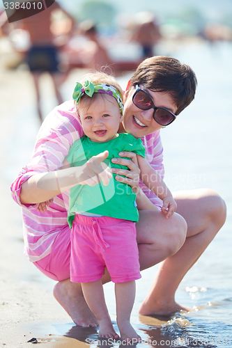 Image of mom and baby on beach  have fun