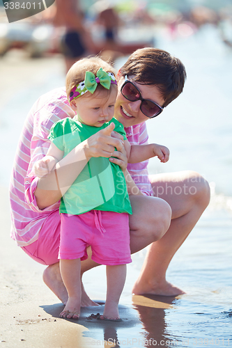 Image of mom and baby on beach  have fun