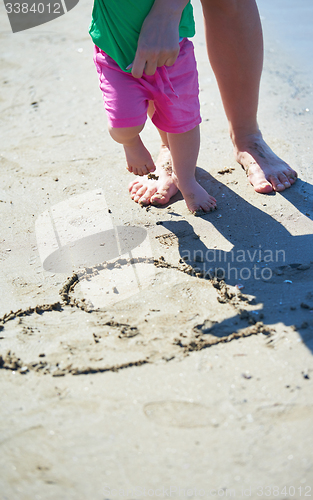 Image of mom and baby on beach  have fun