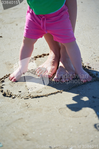 Image of mom and baby on beach  have fun