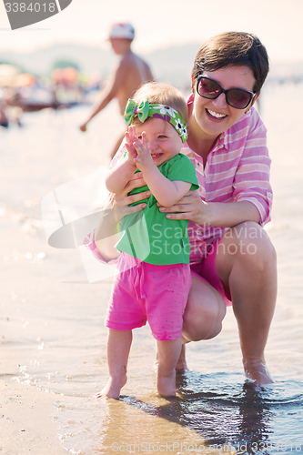 Image of mom and baby on beach  have fun