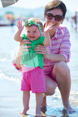 Image of mom and baby on beach  have fun