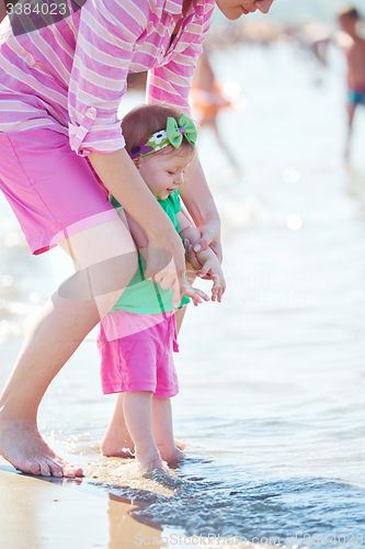 Image of mom and baby on beach  have fun