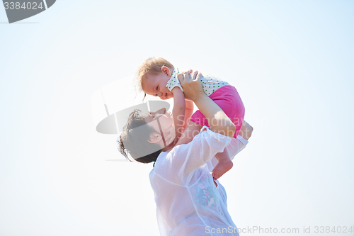 Image of mom and baby on beach  have fun