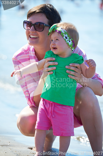 Image of mom and baby on beach  have fun