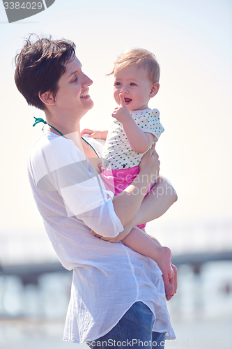 Image of mom and baby on beach  have fun