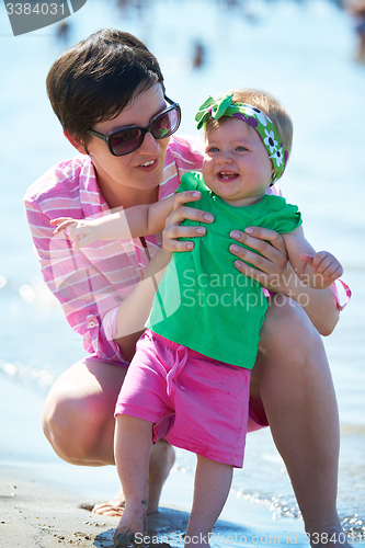 Image of mom and baby on beach  have fun