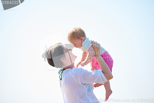 Image of mom and baby on beach  have fun