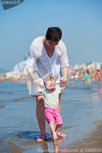 Image of mom and baby on beach  have fun