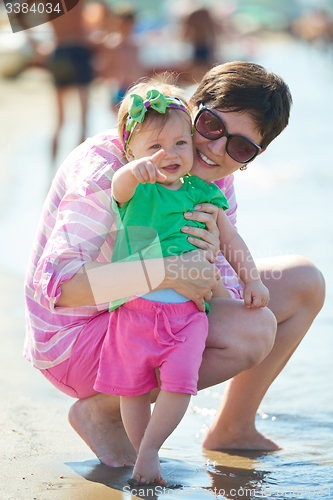 Image of mom and baby on beach  have fun