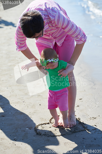 Image of mom and baby on beach  have fun