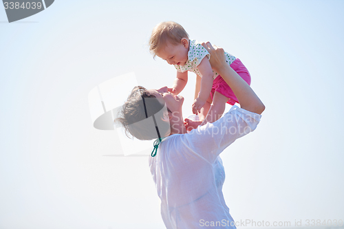 Image of mom and baby on beach  have fun