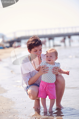 Image of mom and baby on beach  have fun