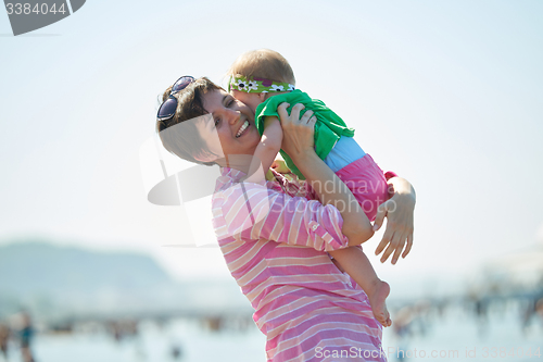 Image of mom and baby on beach  have fun