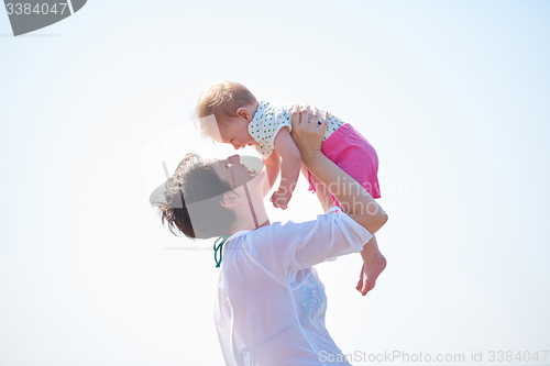 Image of mom and baby on beach  have fun