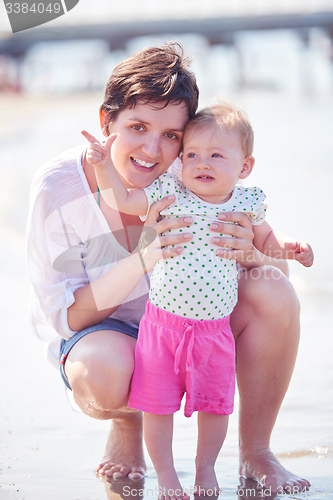 Image of mom and baby on beach  have fun