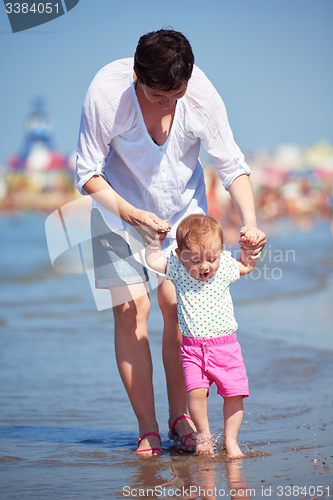 Image of mom and baby on beach  have fun