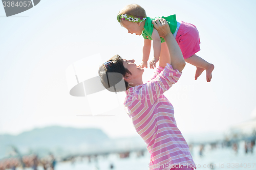 Image of mom and baby on beach  have fun