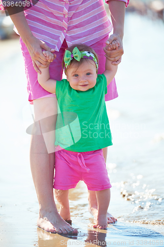 Image of mom and baby on beach  have fun