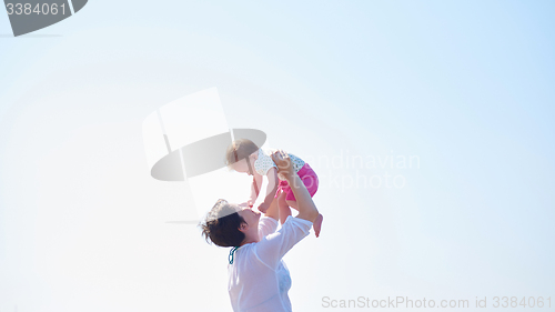 Image of mom and baby on beach  have fun