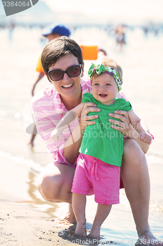 Image of mom and baby on beach  have fun