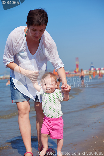 Image of mom and baby on beach  have fun