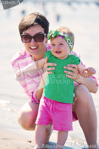 Image of mom and baby on beach  have fun