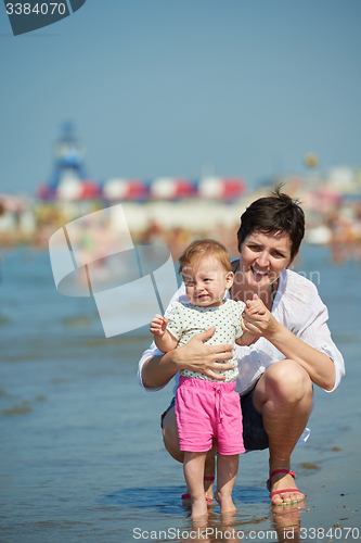 Image of mom and baby on beach  have fun