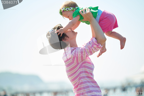 Image of mom and baby on beach  have fun