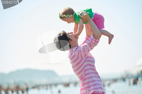 Image of mom and baby on beach  have fun