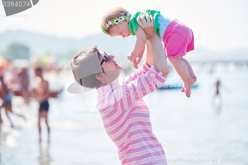 Image of mom and baby on beach  have fun