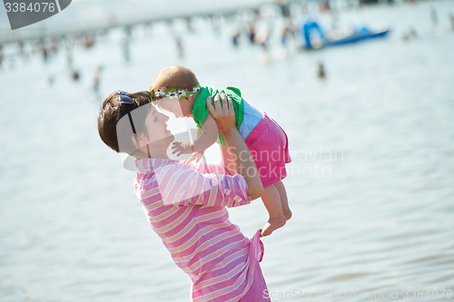 Image of mom and baby on beach  have fun