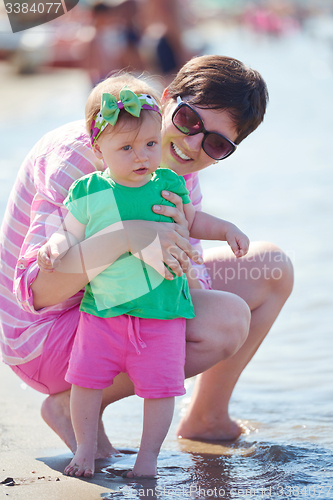 Image of mom and baby on beach  have fun