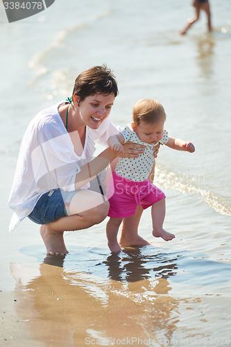 Image of mom and baby on beach  have fun