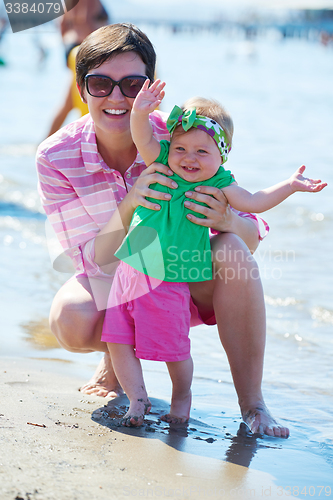 Image of mom and baby on beach  have fun