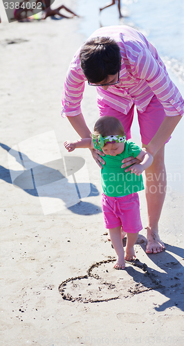 Image of mom and baby on beach  have fun