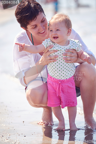 Image of mom and baby on beach  have fun