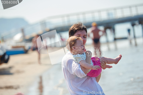 Image of mom and baby on beach  have fun