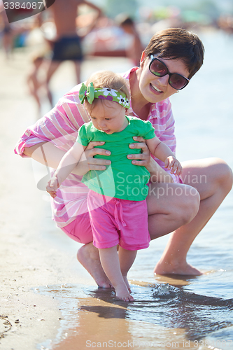 Image of mom and baby on beach  have fun
