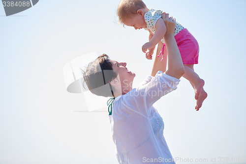 Image of mom and baby on beach  have fun